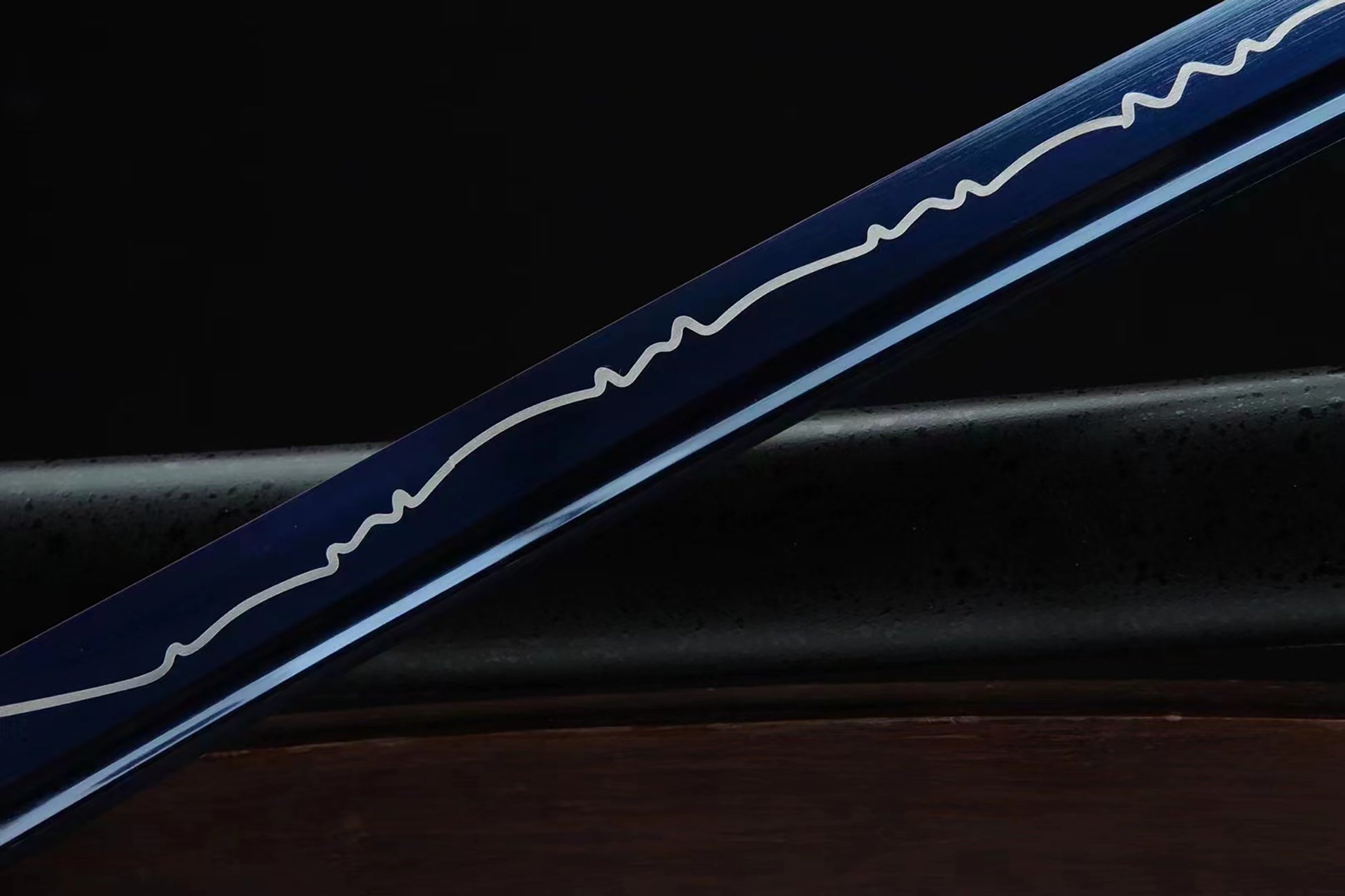 Blue sword with white patterns on a dark background