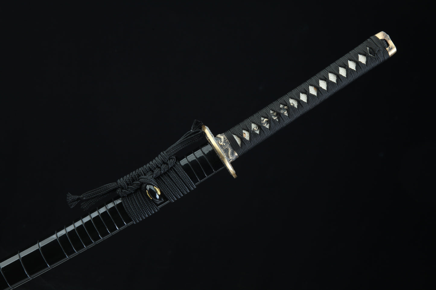 Black cord-wrapped tsuka handle of Jaryū katana with authentic stingray leather samegawa and bronze menuki fittings