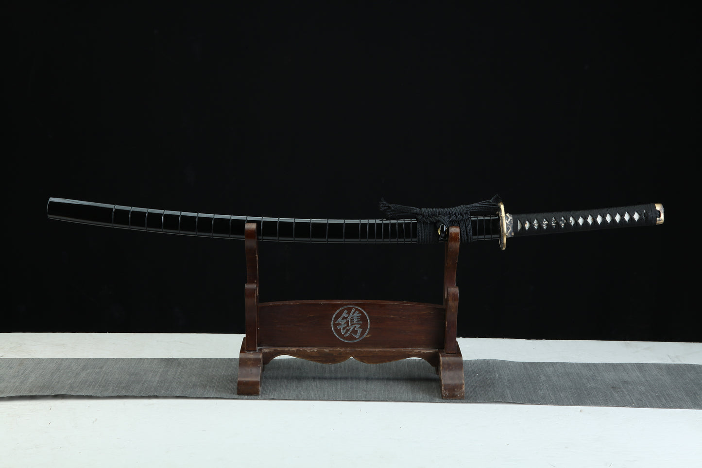 Sword on a wooden stand with a black background
