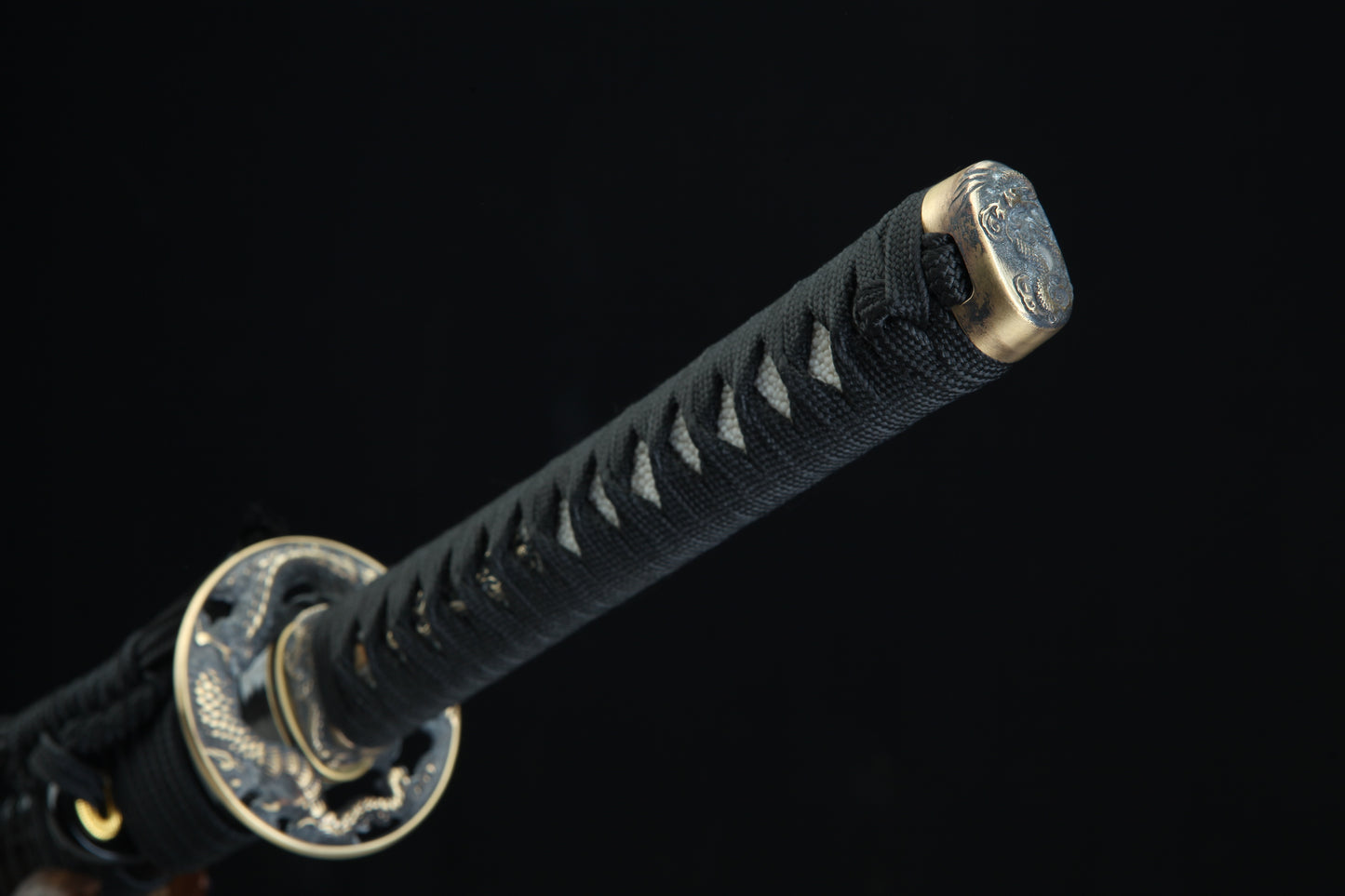 Black cord-wrapped tsuka handle of Jaryū katana with authentic stingray leather samegawa and bronze menuki fittings