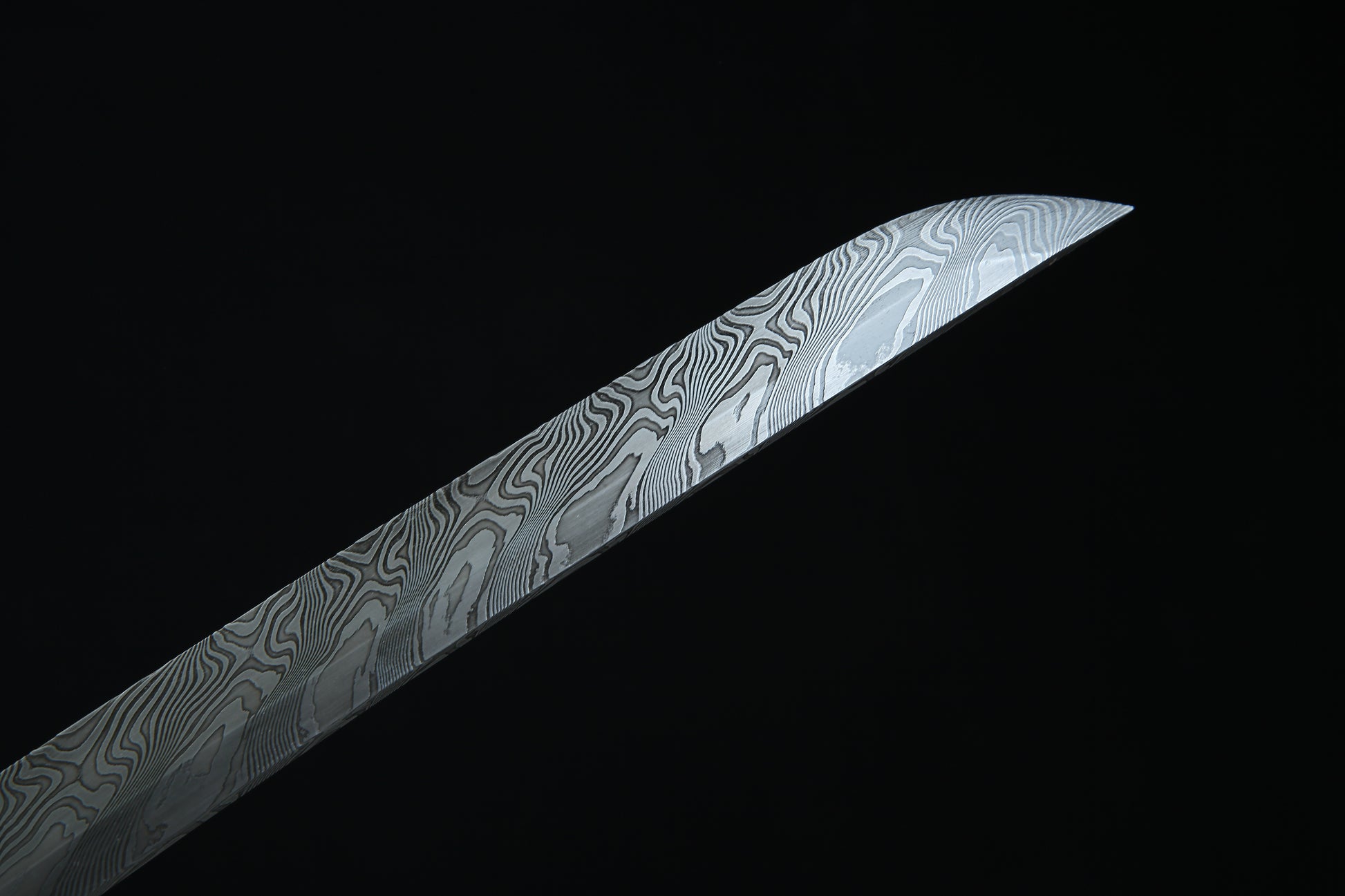 Decorative sword blade with intricate patterns on a black background