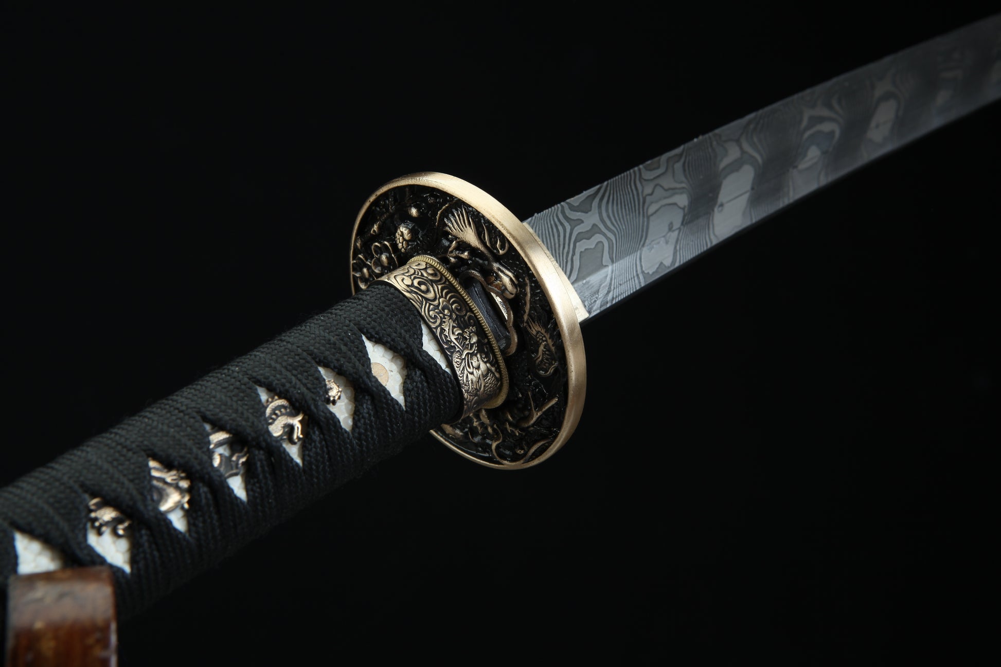 Bronze tsuba guard of Fūrai katana featuring traditional Japanese metalwork complementing Damascus steel blade