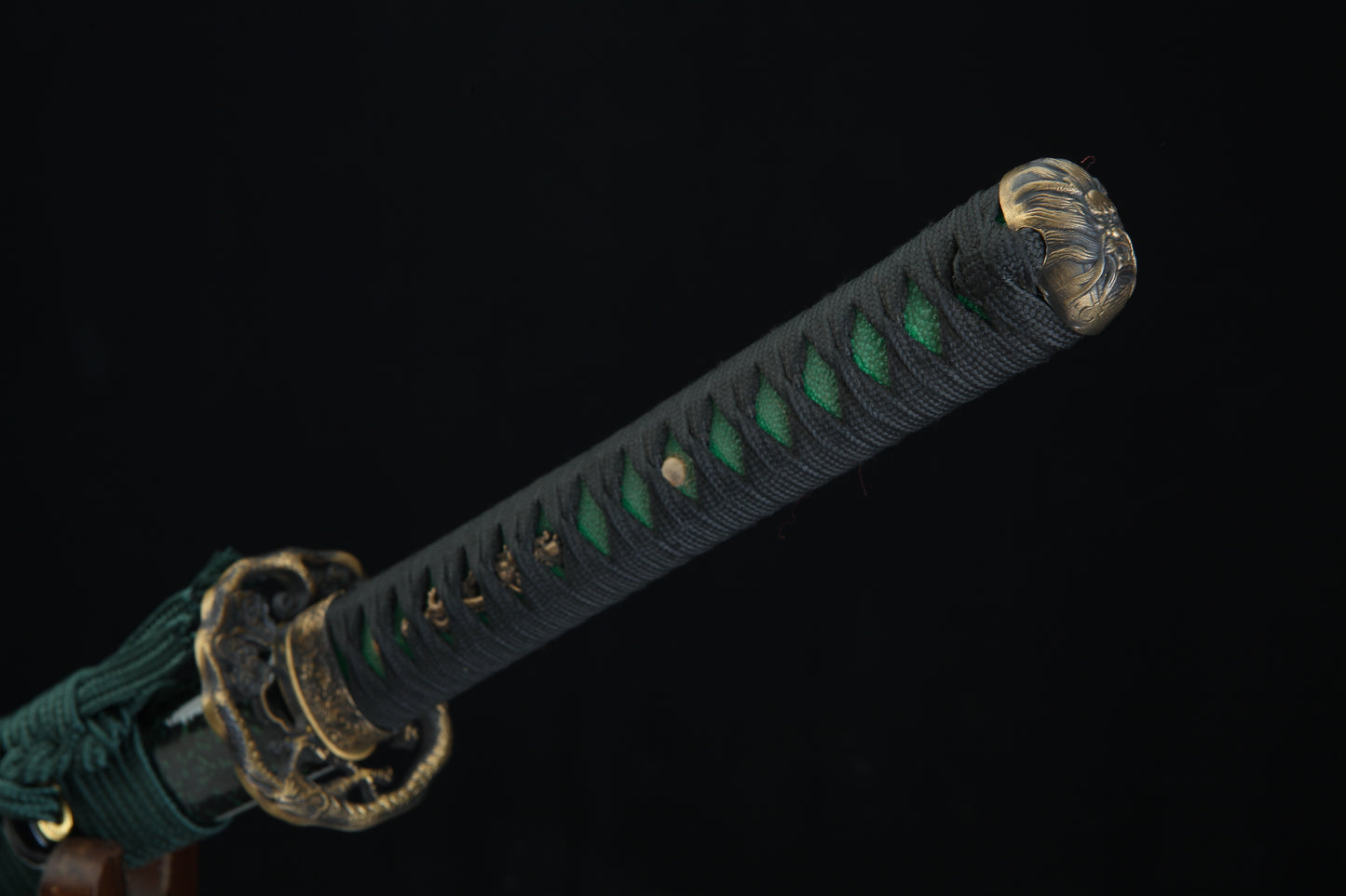 Sword with a black sheath featuring green accents on a black background