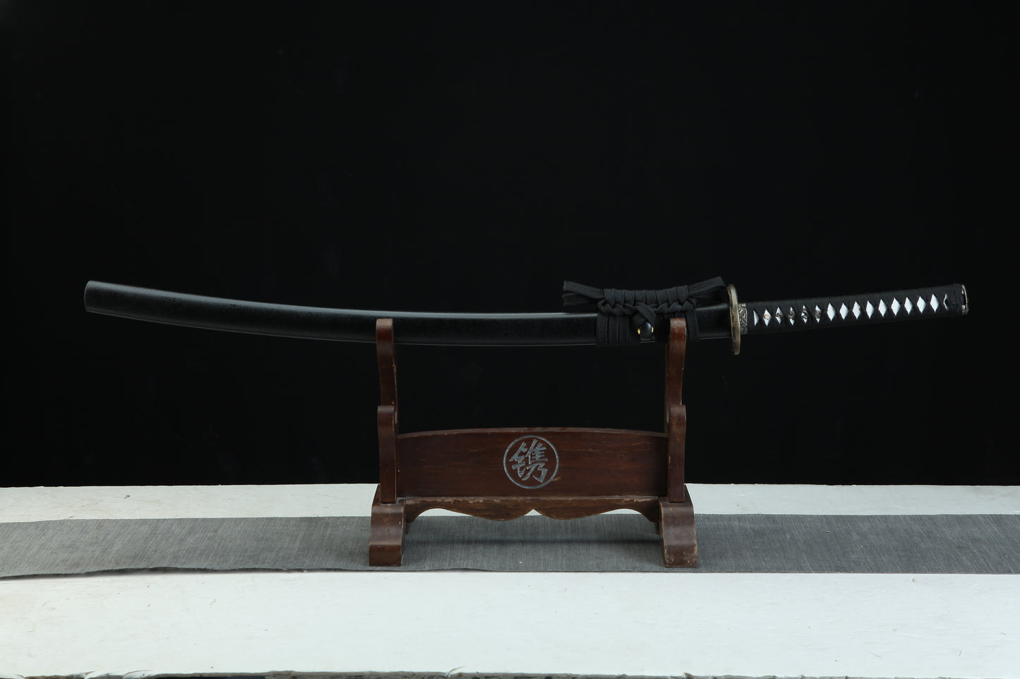 Sword on a wooden stand with a black background