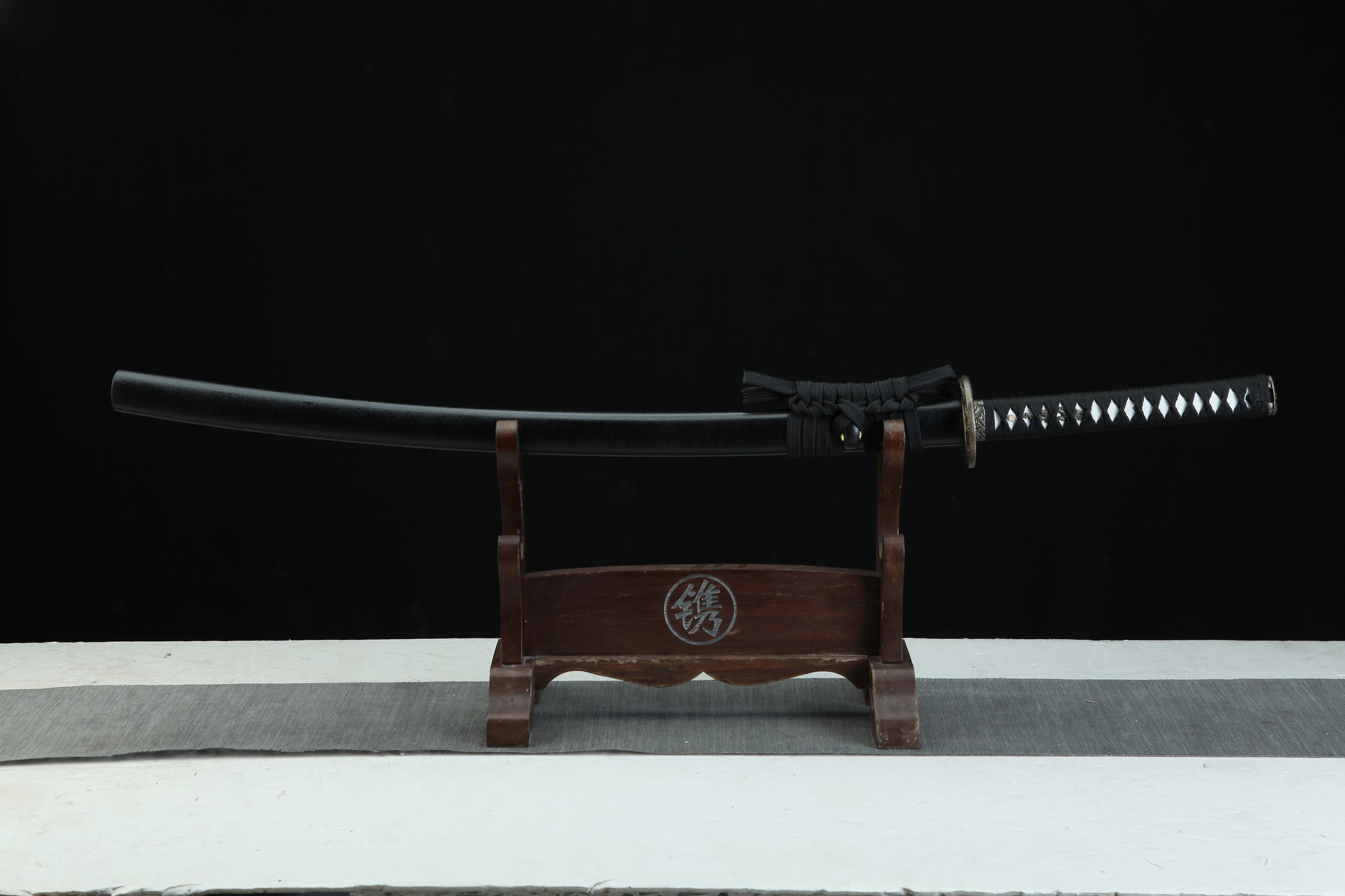 Sword on a wooden stand with a black background