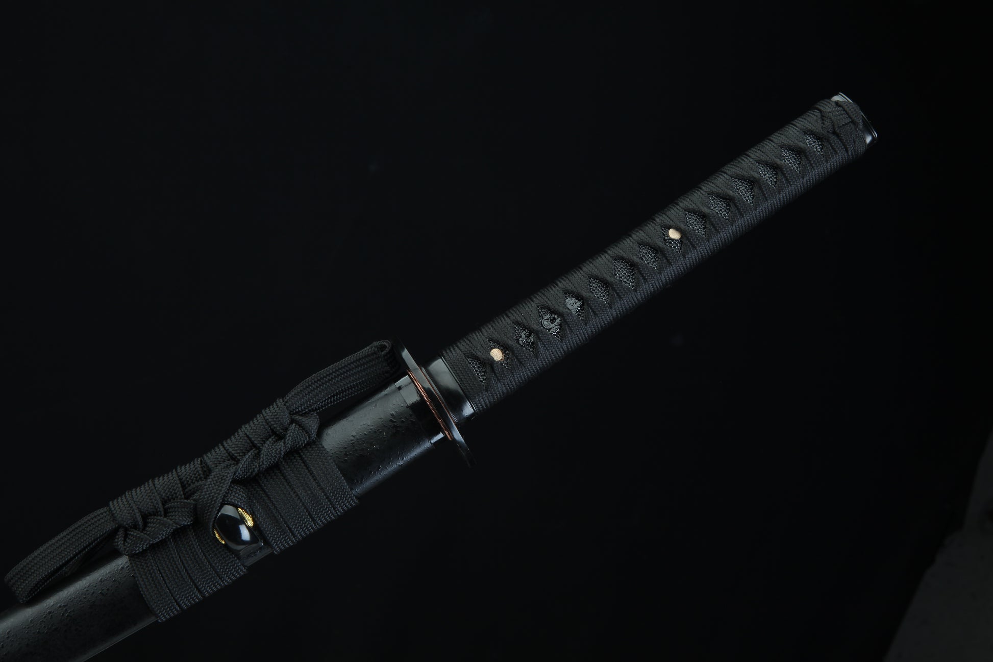 Black sword with textured handle on a black background