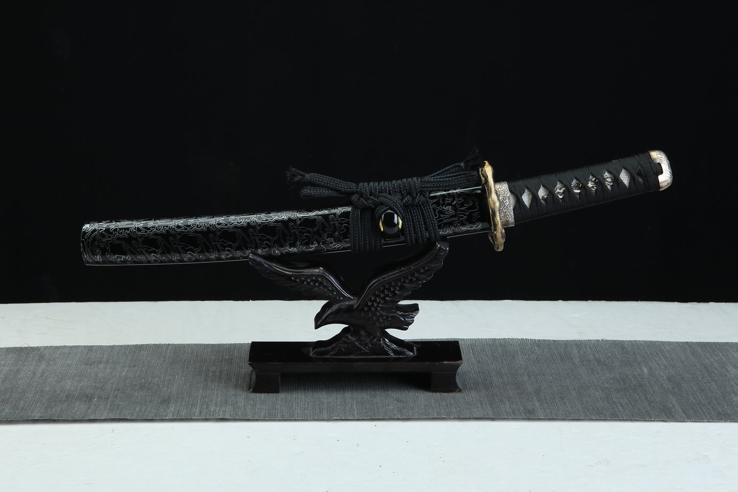 Black lacquered wooden saya with white pattern design of Tengyaku tanto featuring black cord wrapping and traditional finish