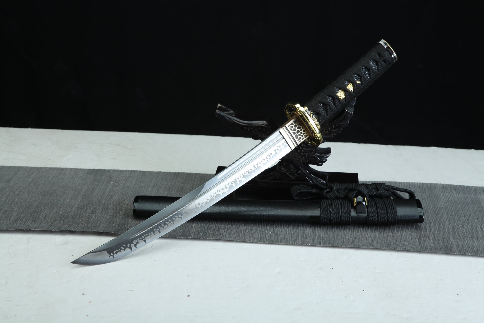 Sword with sheath on a black and white striped background