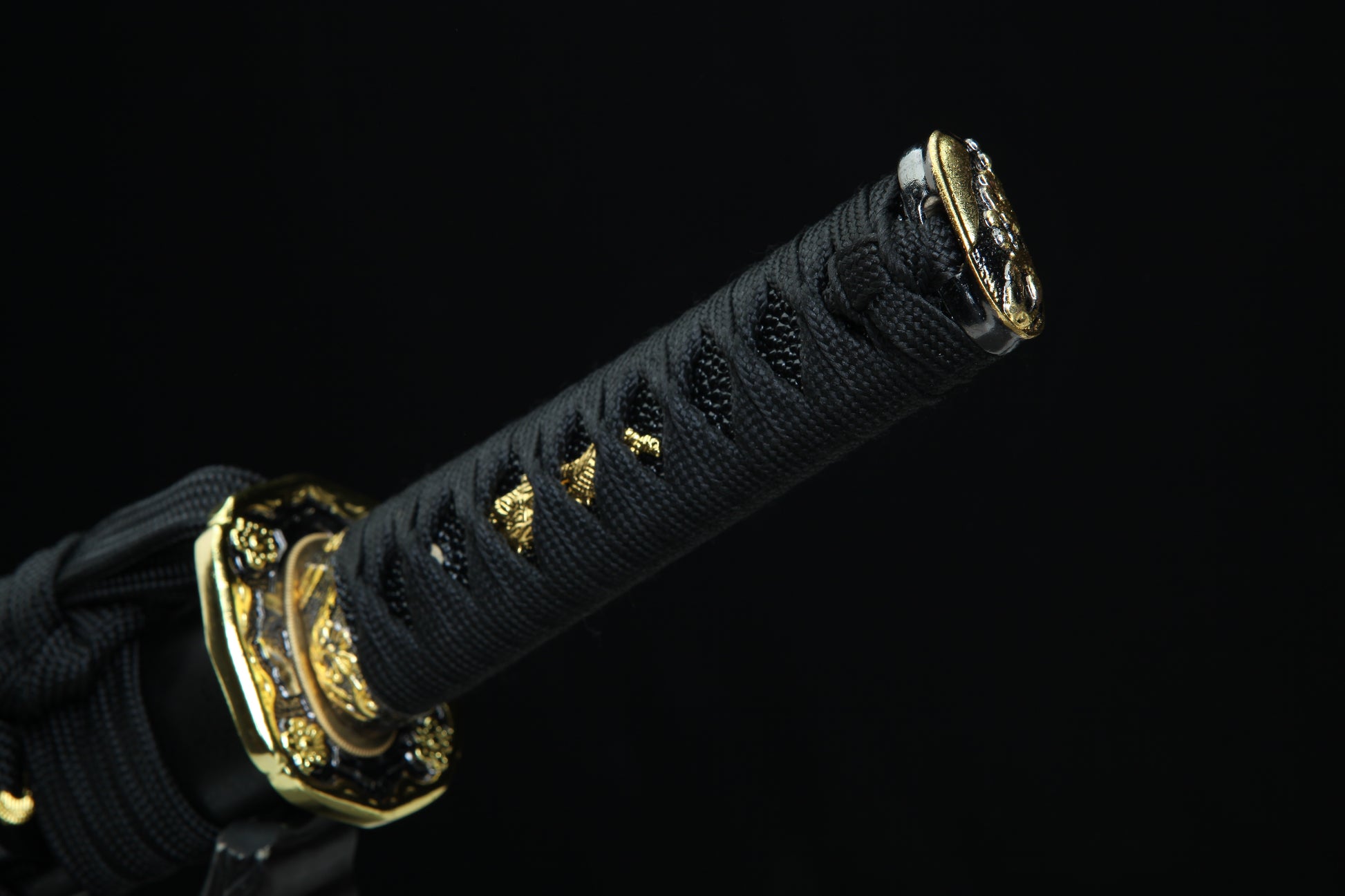 Black sword handle with gold accents on a black background