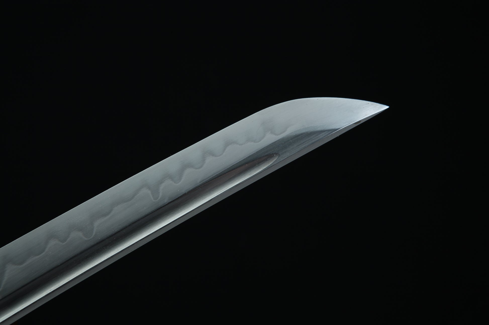 Sword blade with intricate patterns on a black background