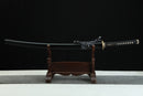 Sword on a wooden stand against a black background