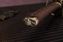 Close-up of Moonswords Banrin katana handle with intricate designs on a textured surface.