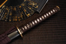 A close-up view of Moonswords Banrin Katana with bronze guard, black handle and black shealth.