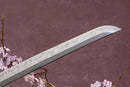A close-up view of a Clay-Tempered T10 Steel blade against a textured background.