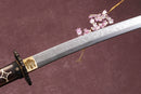 A close-up view of a clay-tempered 1095 steel blade against a textured background