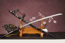 A close-up view of Moonswords Furin Kazan Katana, with a black handle and white accents, featuring intricate designs and patterns.