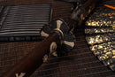 A photo of Moonswords Furin Kazan Katana in black, with a bronze guard, is shown against a dark, slatted bamboo mat background.