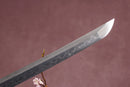 A close-up view of a clay-tempered 1095 steel blade against a textured background