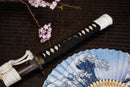 A close-up view of Moonswords Ghost of Yotei Katana with bronze guard, black handle and black shealth.