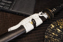 A close-up view of Moonswords Ghost of Yotei Katana with bronze guard, black handle and black shealth.