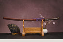A close-up view of Moonswords Hi No Ko Katana, with a brown handle and white accents, featuring intricate designs and patterns.