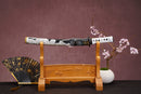 A close-up view of Moonswords Ghost of Tsushima Tanto, with a white handle and black accents, featuring intricate designs and patterns.