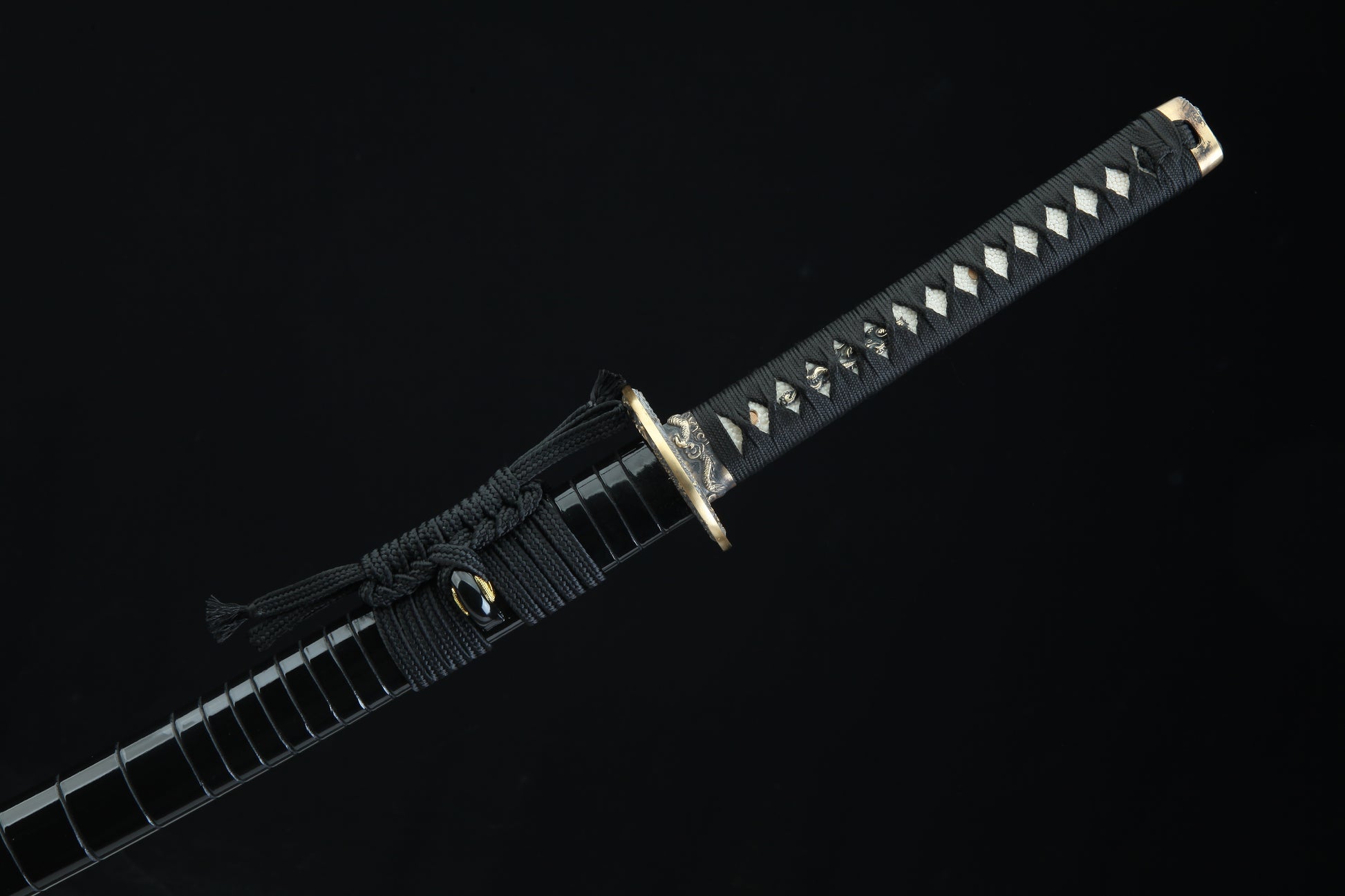Black cord-wrapped tsuka handle of Jaryū katana with authentic stingray leather samegawa and bronze menuki fittings