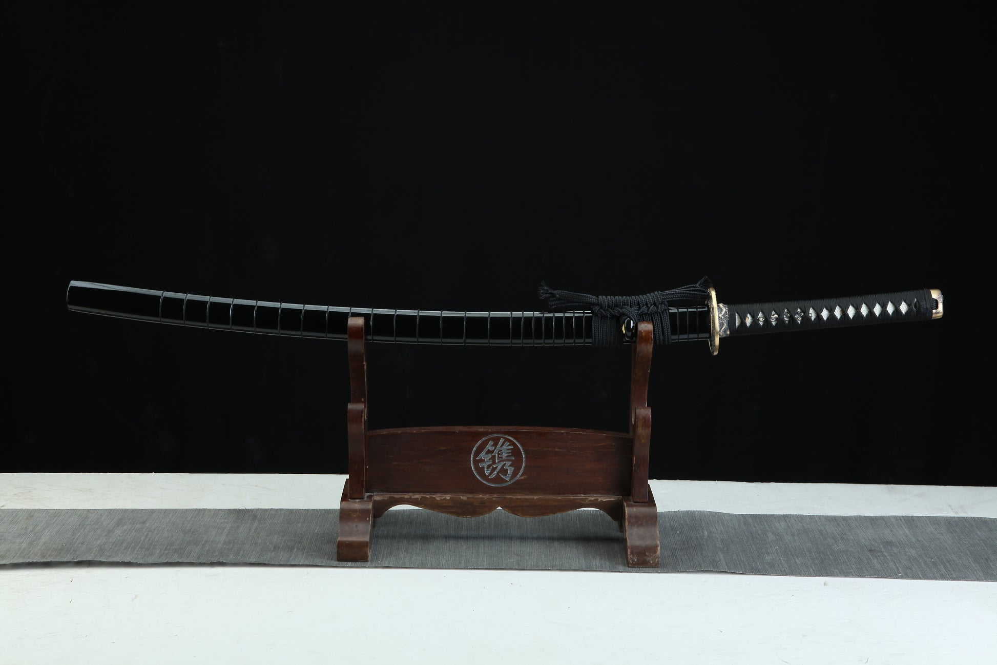 Sword on a wooden stand with a black background