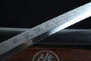 Close-up of a sword blade with engraved patterns on a dark background