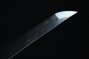 Close-up of a sword blade with engraved patterns on a black background