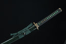 Decorative sword sheath with green fabric and gold accents on a black background