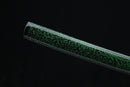 Close-up of a green and black textured object on a black background