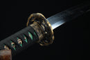 Close-up of a sword with a decorative hilt on a black background