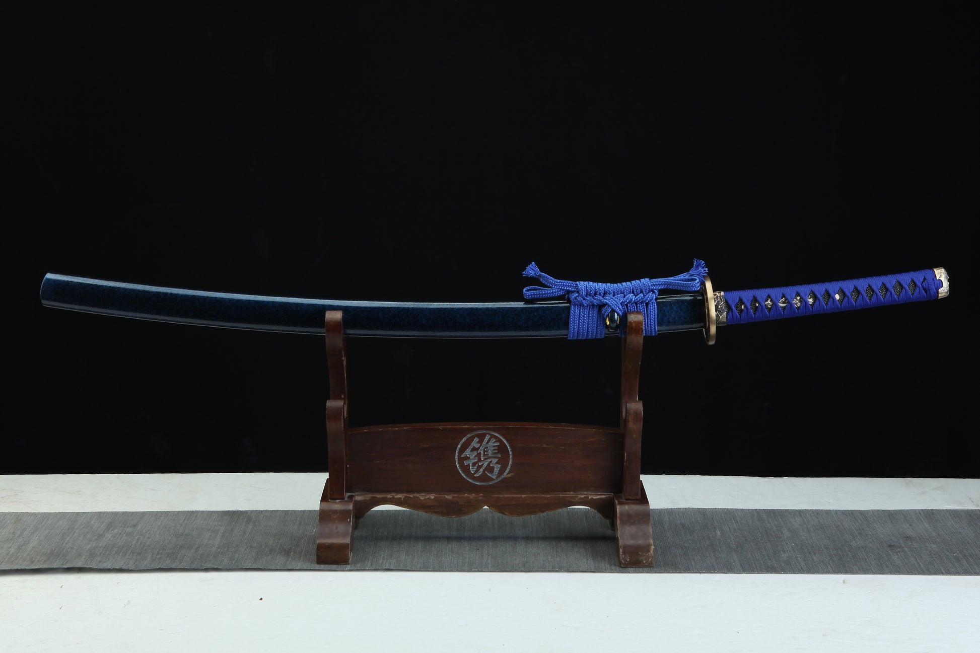 Sword on a wooden stand with a black background
