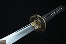 Close-up of a sword with a decorative handle on a black background