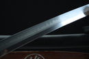 Close-up of a sword blade with engraved text on a dark background