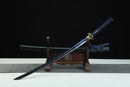Blue sword with gold accents on a wooden stand against a black background