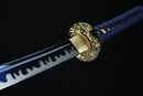 Close-up of a sword with a gold handle against a black background