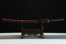 Sword with red blade on a wooden stand against a black background