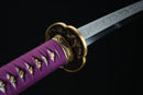 Sword with purple sheath and gold details on a black background