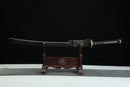 Sword on a wooden stand against a black background