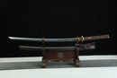 Two swords on a wooden stand with a black background