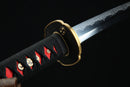 Sword with a black sheath featuring red and gold decorative elements on a dark background