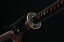 Sword with a black sheath featuring red and gold decorative elements on a dark background