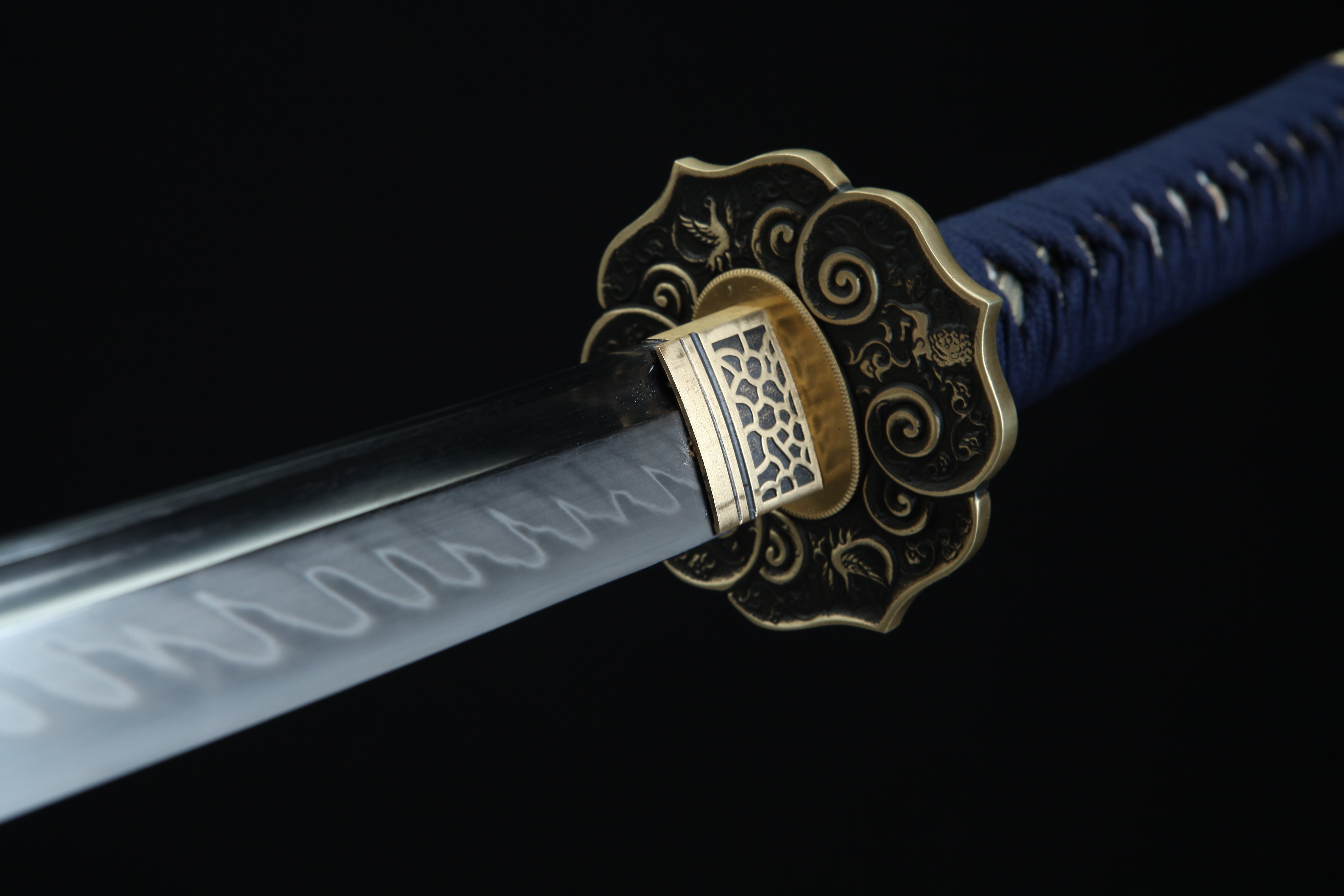 Close-up of the Moonswords Shuren Katana's tsuba and clay-tempered 1095 high-carbon steel blade, showing the hamon line