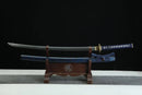 Sword with blue sheath on a wooden stand against a black background