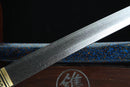 Close-up of a sword blade with engraved patterns on a dark background