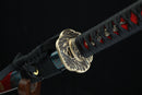 Close-up of a Japanese sword with a decorative hilt on a black background