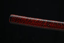 Katana with red and black speckled pattern on a black background