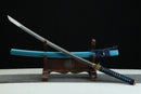 Sword with blue sheath on a wooden stand against a black background